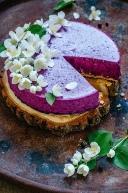 Peynirli kek pişirme olmadan yaban mersini ile Yasemin çiçekleri ile süslenmiş üzerinde eski rustik masaya