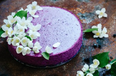 Peynirli kek pişirme olmadan yaban mersini ile Yasemin çiçekleri ile süslenmiş üzerinde eski rustik masaya