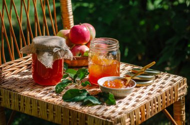 Ev yapımı tatlı elma reçel - organik sağlıklı gıda. Rustik tarzı bir hasır sandalye üzerinde doğada fotoğraf