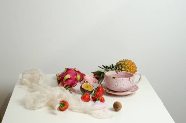 Sevgililer günü için bir mektup kağıt bir kupa, fincan meyve çayı, tutku meyve, çilek, pitahaya, lychee beyaz tablosundaki ile. Üstten görünüm.