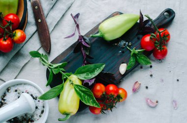 Yüksek açı natürmort görüntülemek çevrili taze çiğ sebze ve baharat, fesleğen masada tahta kesme