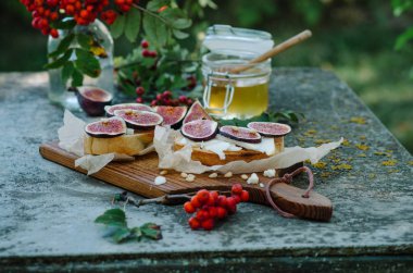Peynir, taze incir, çam fıstığı ve ballı rustik gemide Bruschetta