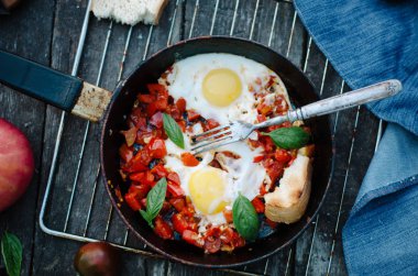 Shakshuka, Pan, rustik tarzı ve ahşap arka plan domates soslu kızarmış yumurta
