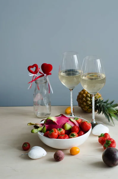 Romantic dinner for two with champagne and fruits. Strawberry, champagne, pineapple, pitahaya, passion fruit, mango. Valentine\'s Day.