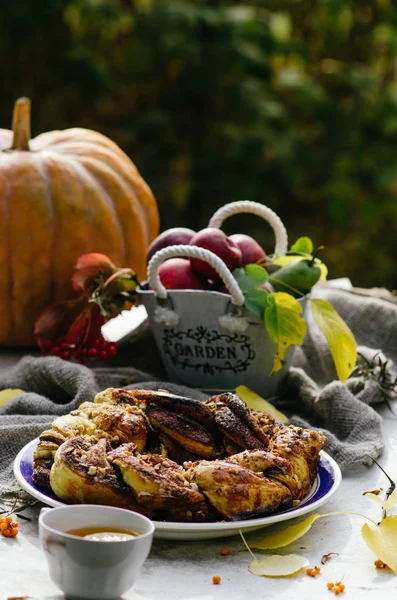 Fırından yeni çıkmış tarçınlı tatlı çörek ve rustik ahşap masa üzerinde süt. Sonbahar arka plan whith kabak, çelenk ve bir sepet elma ve tarçın rulo.
