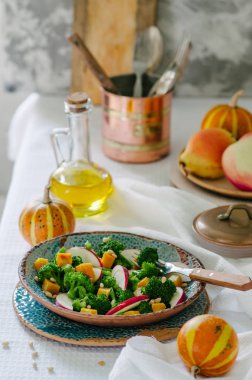 Fırında kabak, elma, brokoli ve çam fıstığı salatası. Seramik plakalar el yapımı. Rustik tarzı.