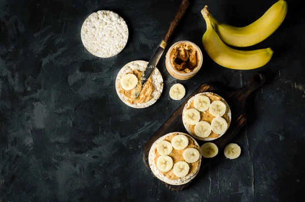 Gâteaux Riz Beurre Arachide Tranches Banane Sur Table Bois Noir — Photo