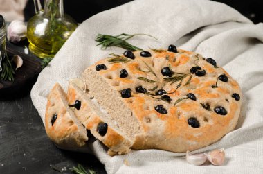 Biberiye ve zeytin siyah ahşap bir masa üzerinde FOCACCE çeşitleri.