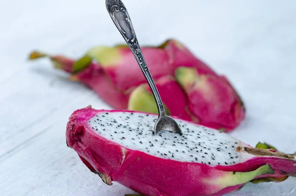 Dos mitades de fruta de dragón con cuchara sobre fondo blanco, fruta tropical —  Fotos de Stock