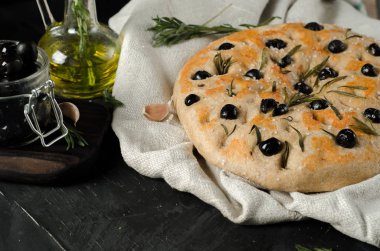Biberiye ve zeytin siyah ahşap bir masa üzerinde FOCACCE çeşitleri.