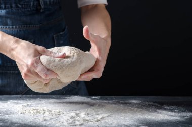 Kadın üzerinde hamur yoğurma un tablo ile serpilir. Ekmek, rulo, pizza, elmalı veya pasta hamur mayaları. Ev yapımı hamur. Metin için tasarım.
