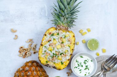 Lezzetli ev yapımı otantik Tayland baharatlı kızarmış pirinç. Ananas kızarmış pilav. Taze malzemelerle - ananas, beyaz pirinç, biber, limon, kaju, sos ve Yeşiller yaptı. Üstten Görünüm. Beyaz arka plan.