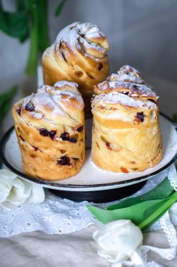 Paskalya kek. Kruffin tatlı pasta pudra şekeri dekore edilmiştir. Beyaz Lale ile tablo Easter.