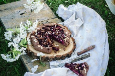 Çikolata kiraz Galette'ye veya pasta bir ahşap tahta üzerinde. Doğada bahar ya da yaz pikniği.