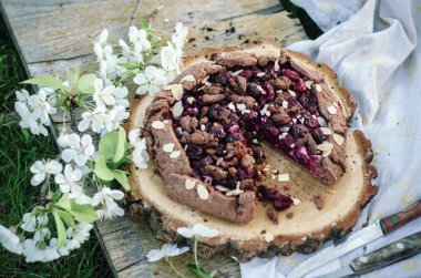 Çikolata kiraz Galette'ye veya pasta bir ahşap tahta üzerinde. Doğada bahar ya da yaz pikniği.