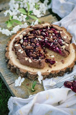 Çikolata kiraz Galette'ye veya pasta bir ahşap tahta üzerinde. Doğada bahar ya da yaz pikniği.