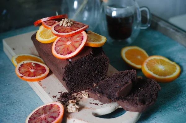 Chokladkaka med med röda och gula apelsiner. — Stockfoto