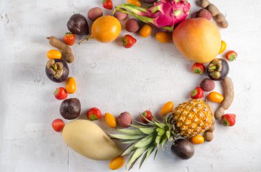 Sağlıklı beslenme, kopya alanı ile bir çerçeve içinde beyaz bir arka plan üzerinde meyve çeşitleri, dikey üst görünüm. Egzotik meyveler