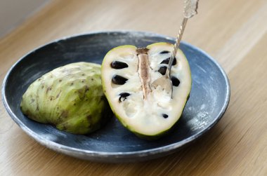 Ahşap bir masa üzerinde siyah plaka üzerinde Cherimoya