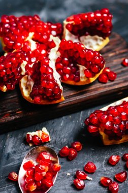 Nar koyu bir arka plan üzerinde kırmızı tanecikleri ile parçalara ayrılmış.