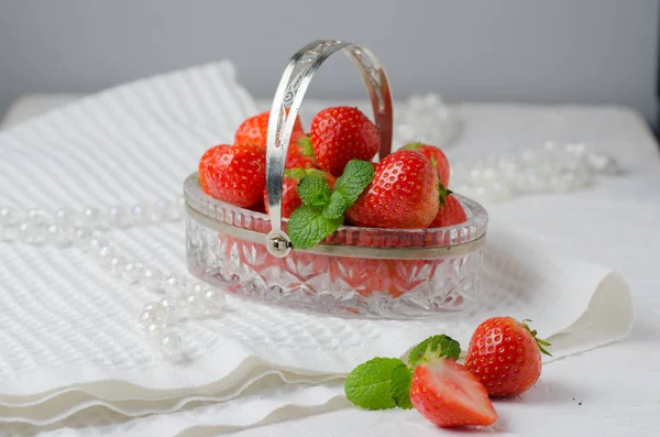 Heap of fresh strawberries in in a crystal basket on white background. Places for text. Postcard — Stock Photo, Image