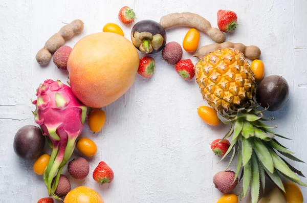 Hälsosam kost, variiteten av frukter på en vit bakgrund i en ram med kopierings utrymme, vertikal uppifrån. Exotiska frukter — Stockfoto