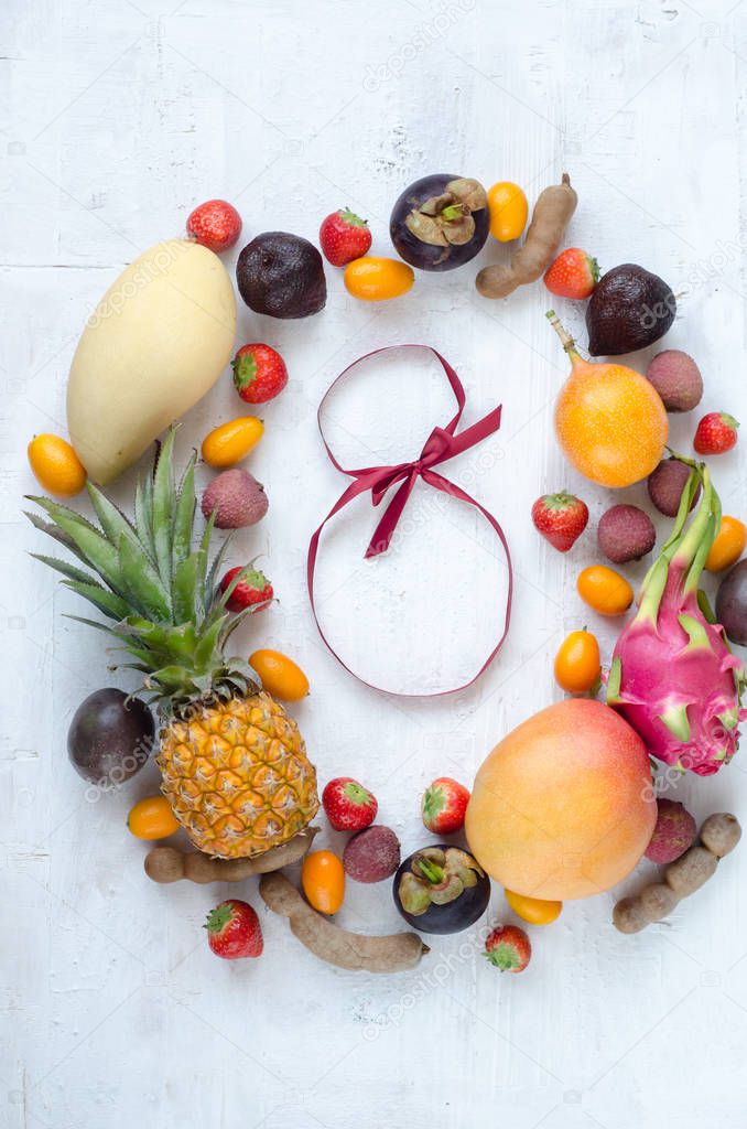 Healthy eating, varieity of fruits on a light background in a frame with copy space, vertical top view. Women's Day. March 8.