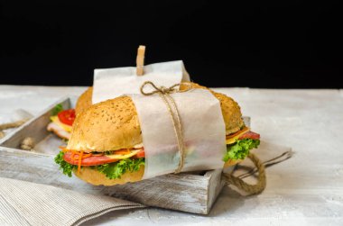 Ahşap bir masada sebze, peynir, jambon, salam ve salata ile sandviç sağlıklı ev yapımı atıştırmalık veya öğle yemeği. Metin için alan