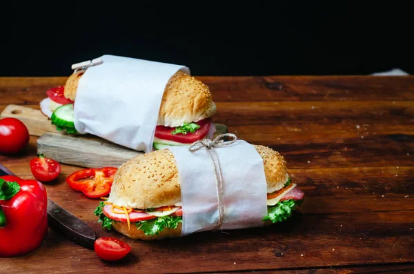 Zdrowe domowe przekąski lub lunch z kanapek z warzywami, serem, szynką, salami i sałatą na drewnianym stole. Miejsce na tekst — Zdjęcie stockowe