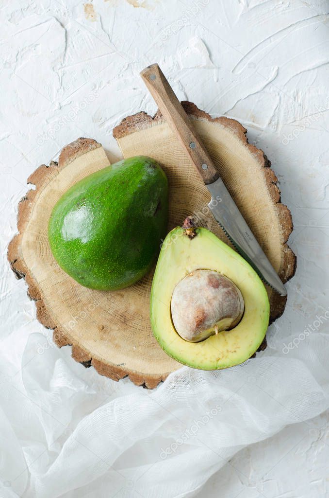 Cut green avocado on a wooden board.