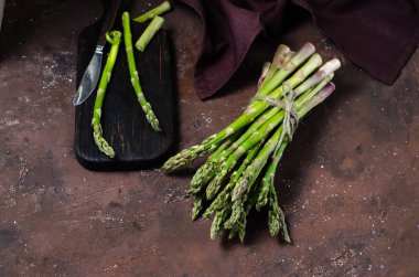 Koyu arka plan üzerinde taze yeşil kuşkonmaz banches