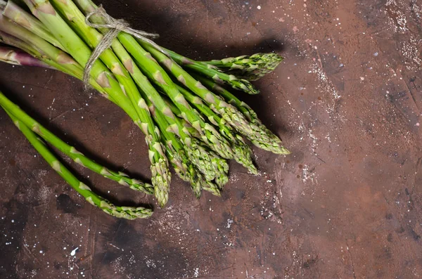 Banches of fresh green asparagus on dark background, top view — Stock Photo, Image