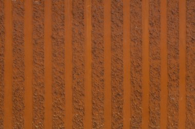Dekoratif ayrıştırma dokusu arka planı. Dikey çizgili bir duvar parçası. Yapısal alçı, pürüzlü, düz olmayan turuncu sarı yüzey.