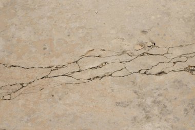 Çatlakları olan eskimiş ve küflenmiş beton bir duvar..