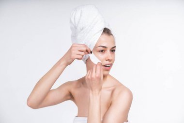 young girl sticks patch for eyes. Nude in a towel on the chest and head. European 20 years old