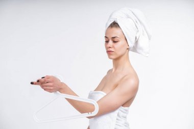 güzel bir genç kızın elinde giysi askısı