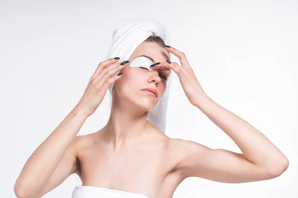 white girl sticks patch for eyes. Nude in a towel on the chest and head. on an empty background. Portrait