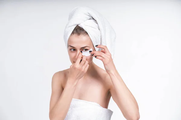 white girl sticks patch for eyes. Nude in a towel on the chest and head. on an empty background. Portrait