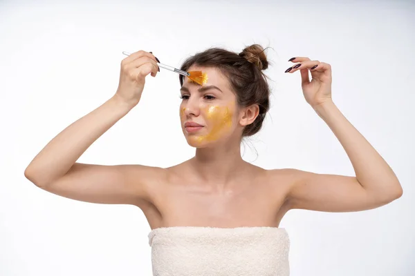 a young girl puts on a face mask for the first time in her life. Can not. Bad skin of the face. Acne on the face. Natural, no makeup. European 25 years old, white