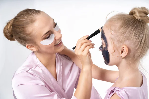 Sœurs s'entraident pour enlever les masques faciaux du visage pour guérir la peau. Amusez-vous bien ensemble et amusez-vous . — Photo