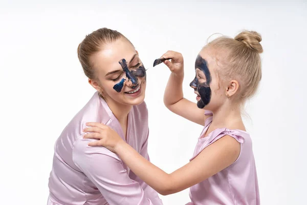 Sœurs s'entraident pour enlever les masques faciaux du visage pour guérir la peau. Amusez-vous bien ensemble et amusez-vous . — Photo