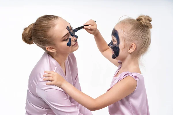 Schwestern helfen sich gegenseitig, Gesichtsmasken aus dem Gesicht zu entfernen, um die Haut zu heilen. Gemeinsam eine tolle Zeit haben und Spaß haben. — Stockfoto