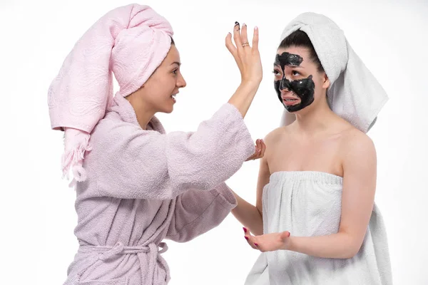 Fidanzate si aiutano a vicenda mettere sul viso una maschera cosmetica, divertirsi e indulgere nel processo. Le ragazze si prendono cura l'una dell'altra e si divertono . — Foto Stock