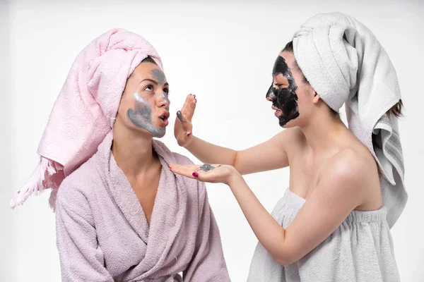 sisters help each other in facials, apply a cosmetic mask, communicate, hug and have fun in the process. They love each other.