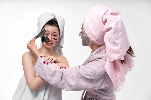 sisters help each other to remove face masks from the face to heal the skin. Have a great time together and have fun.