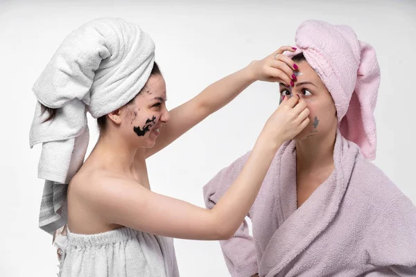 Soeur aide à enlever le masque cosmétique sur les soins du visage. Les filles s'amusent et passent un bon moment pendant la procédure. De nombreuses options pour de telles photos . — Photo