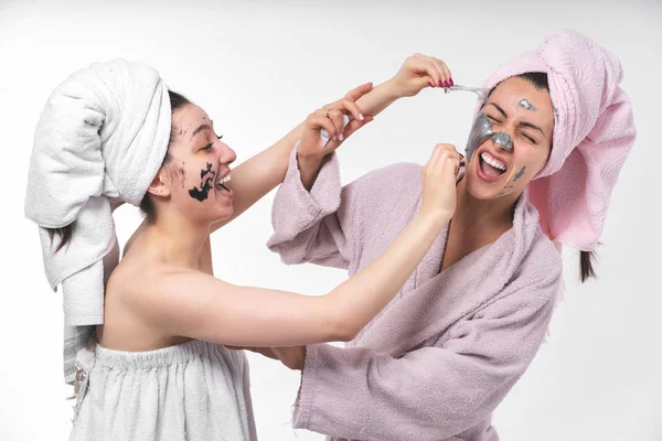 Le lesbiche si aiutano a vicenda a rimuovere le maschere facciali dal viso per guarire la pelle. Divertitevi insieme e mostrate sentimenti . — Foto Stock
