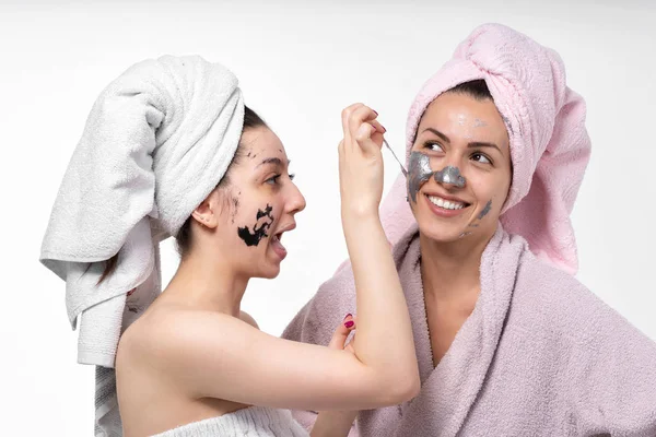 Gli amici vicini insieme sono impegnati in procedure cosmetiche per ringiovanimento facciale. Divertiti e divertiti. Mostra sentimenti gli uni per gli altri . — Foto Stock
