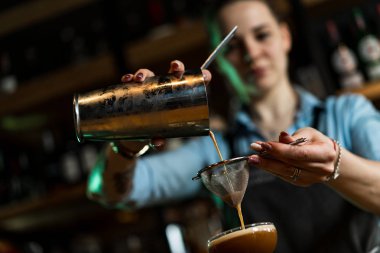 kız barmen shaker ve bar süzgeci ile kokteyl hazırlanıyor