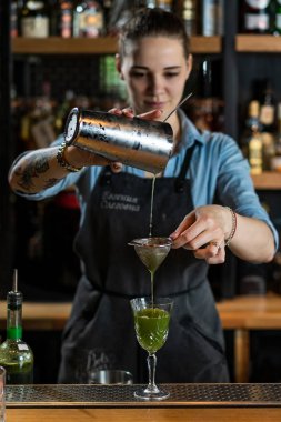 kız barmen shaker ve bar süzgeci ile kokteyl hazırlanıyor